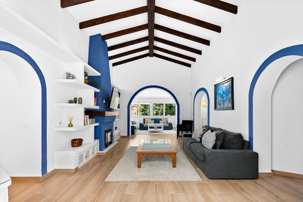 Una sala de estar moderna con chimenea, un sofá, una mesa de centro y una estantería.