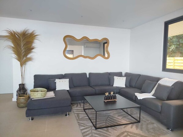 A modern living room with a sectional sofa, a coffee table, and decorative items.