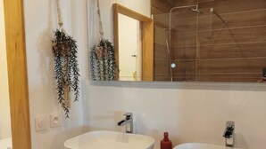 A modern bathroom with two large, white, oval sinks, a large mirror, and a wooden shower enclosure. - An unusual haven of peace overlooking the turquoise lagoon of Haapiti in Moorea (Moorea-Maiao)
