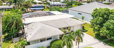 A residential area with houses, palm trees, and a clear sky.