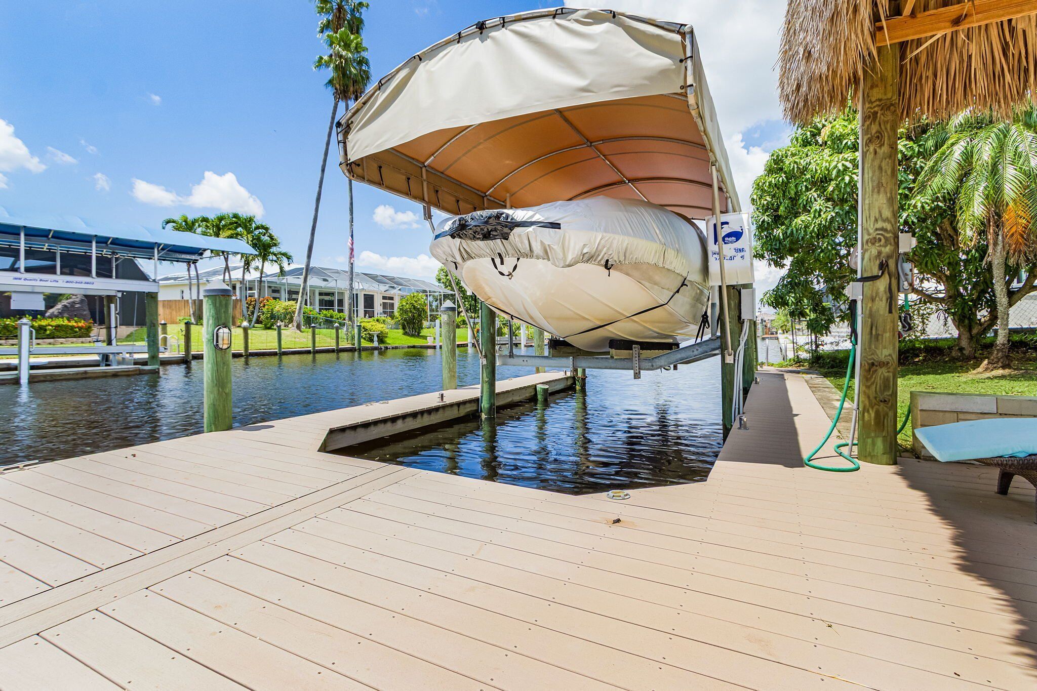 A dock with a canopy, a bench, and a water body.