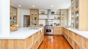 Une cuisine moderne avec des meubles en bois, un îlot central, une cuisinière et un évier.