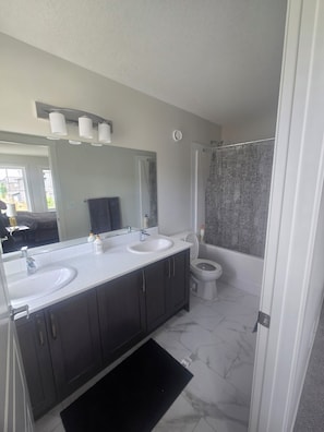 Een haardroger, handdoeken, zeep, toiletpapier