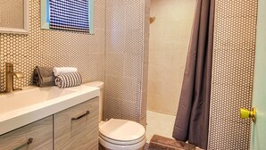 Une salle de bain comprenant des toilettes, un lavabo et une douche.