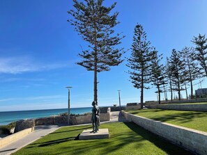 A statue in a park with a clear view of the ocean.