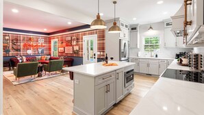 A modern kitchen with a central island, white cabinetry, and pendant lighting.