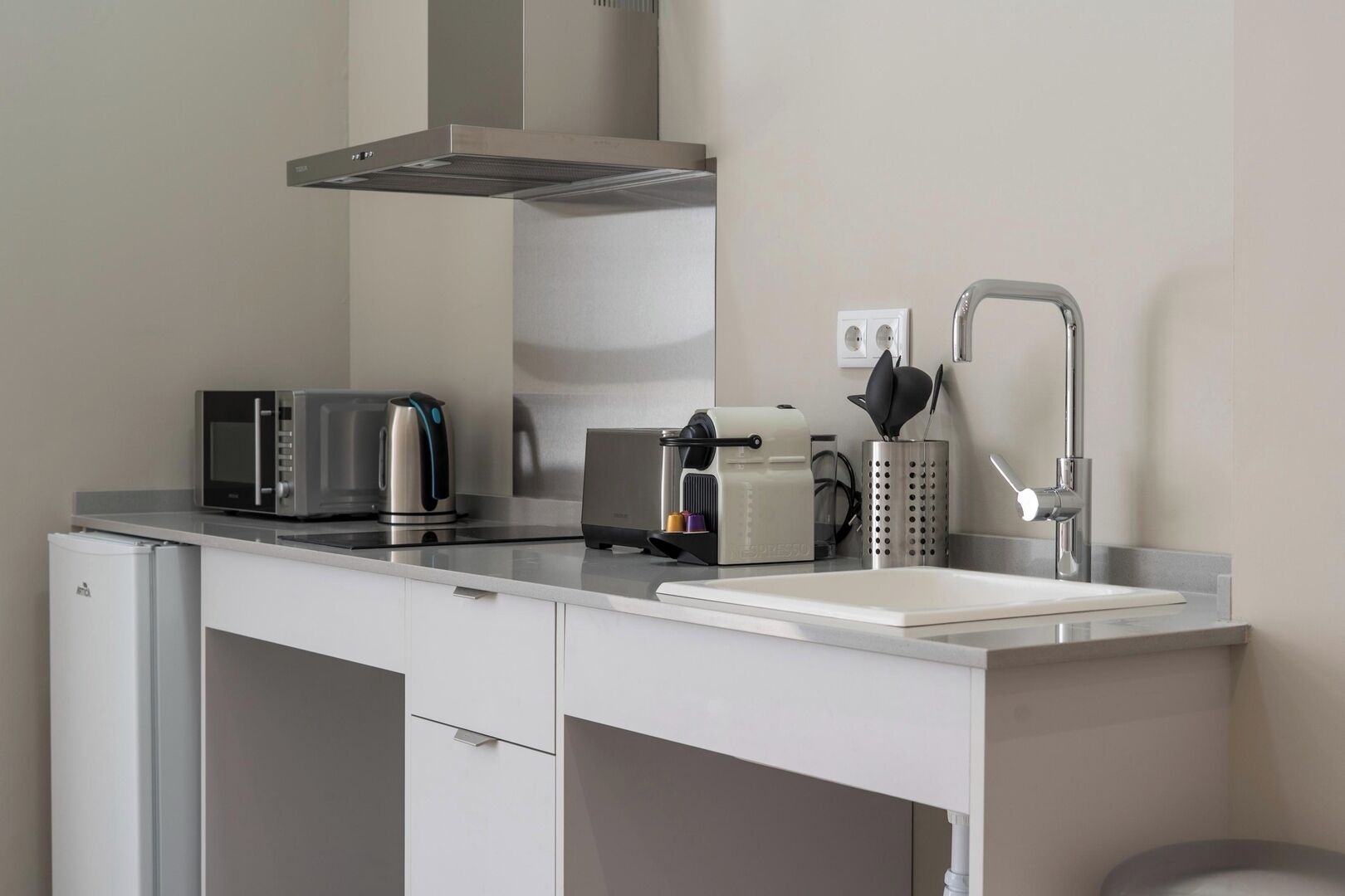 Eine moderne Küchenzeile mit Mikrowelle, Toaster, Wasserkocher und Espressomaschine.