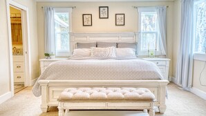 A bedroom with a large bed, a bedside table, a bench, and a wardrobe. - MountainTop Mega A Frame Chalet with Hot Tub (Black Hawk)