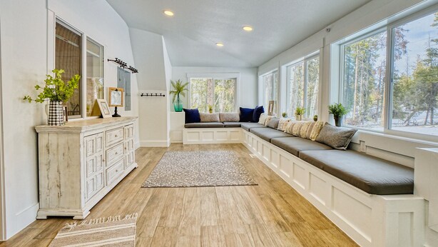 A spacious room with a built-in bench along the window, a white cabinet, and a large mirror. - MountainTop Mega A Frame Chalet with Hot Tub (Black Hawk)