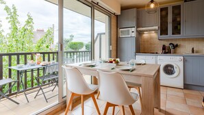 A modern kitchen with a dining area, large windows, and a washing machine. - Le Surcouf by Interhome (Cabourg)