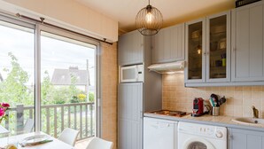 A modern kitchen with a built-in washing machine, a microwave, and a gas stove. - Le Surcouf by Interhome (Cabourg)