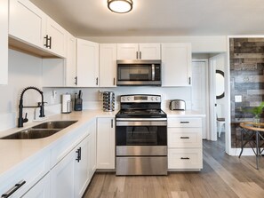 Fridge, microwave, coffee/tea maker, cookware/dishes/utensils