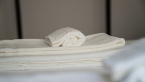 Un montón de toallas blancas sobre una cama.
