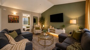 A living room with sofas, a coffee table, a TV, and a plant. - Austin 3BR Home for Families & Groups · Sleeps 10 · 10min to UT (Austin)