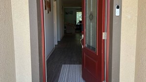 A red door with a glass panel and a doorbell. - Spacious 5-bedroom house in welcoming Sebastian with WiFi, AC (Vero Beach)
