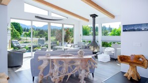 Un salon moderne avec une grande table basse en bois, des canapés gris et une cheminée.