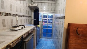 A narrow kitchen with a stove, sink, and cabinets.