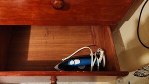 Eine Holzkassette mit einem Schuhpaar und einer blauen Flasche darin.