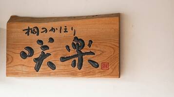 A wooden plaque with Japanese calligraphy and a red seal.