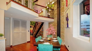 A dining area with a wooden table set for four, teal upholstered chairs, and a staircase leading to an upper level. - CASA ESMERALDA, duplex raffiné de 120m2 (Panama)