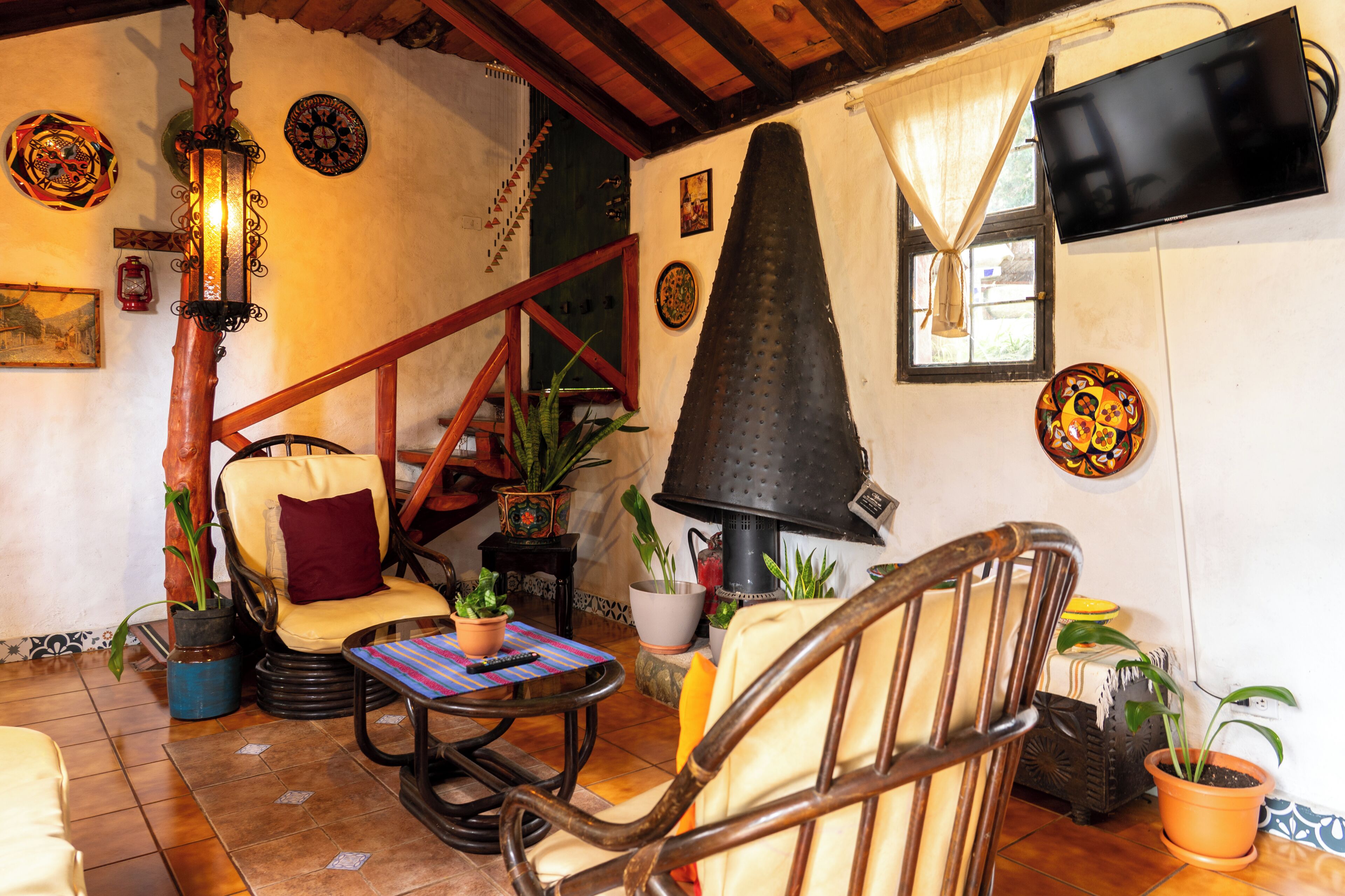 A cozy room with a fireplace, wooden furniture, and various decorative items.