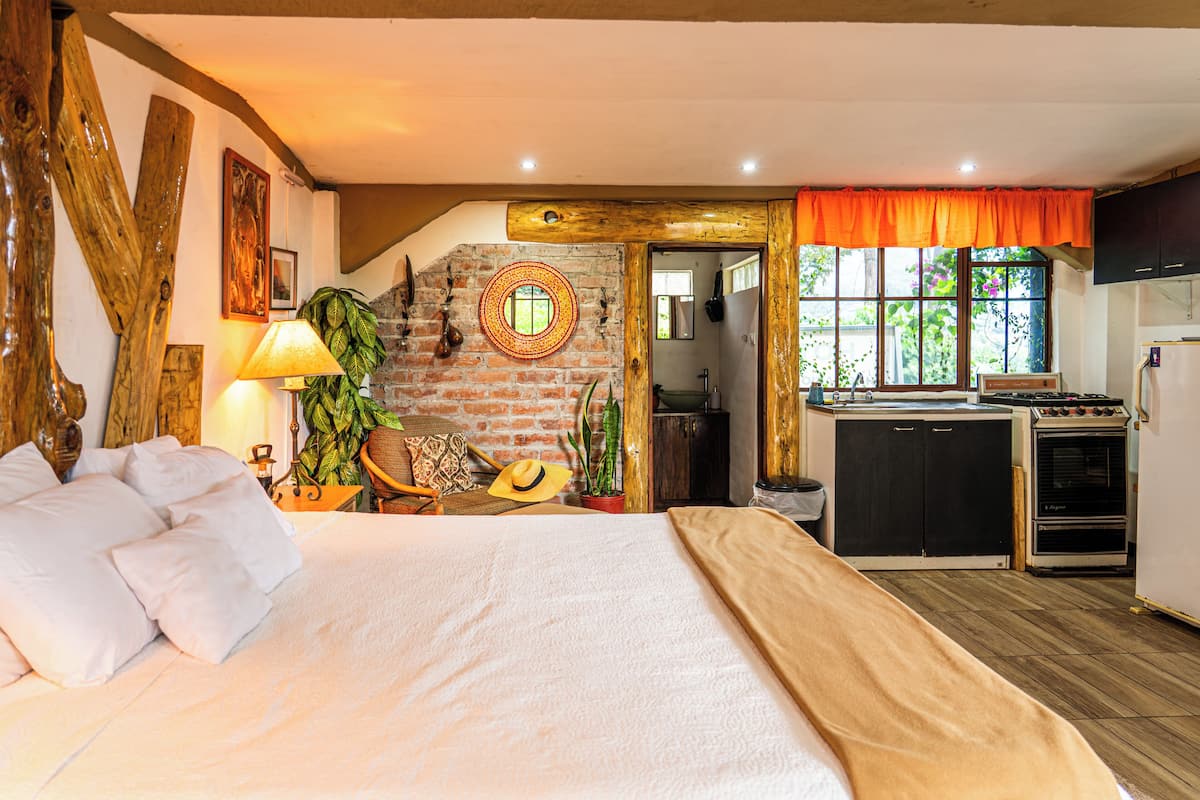 Une chambre à coucher avec un lit, des oreillers, une lampe et une horloge fixée au mur.