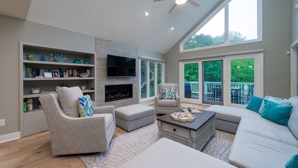 Amplia sala de estar con chimenea, asientos cómodos, televisor de pantalla plana y ventanas grandes que ofrecen vistas al exterior.