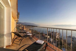 A balcony with lounge chairs and a view of the sea and mountains. - Sea View Panorama Penthouse, Senj, Croatia (Senj)