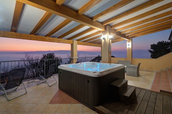 A hot tub under a wooden pergola with a view of the sunset over a mountainous landscape. - Sunset And Sea View Apartment, Senj, Croatia (Senj)