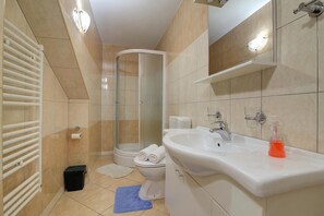 A modern bathroom with a shower, toilet, and sink.