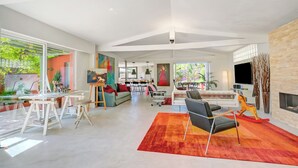 A spacious living area with a large window, a fireplace, and a modern sofa.