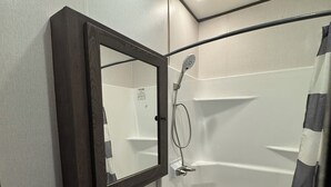 Un bagno moderno con lavabo incassato, uno specchio, cabina doccia e vasca da bagno.
