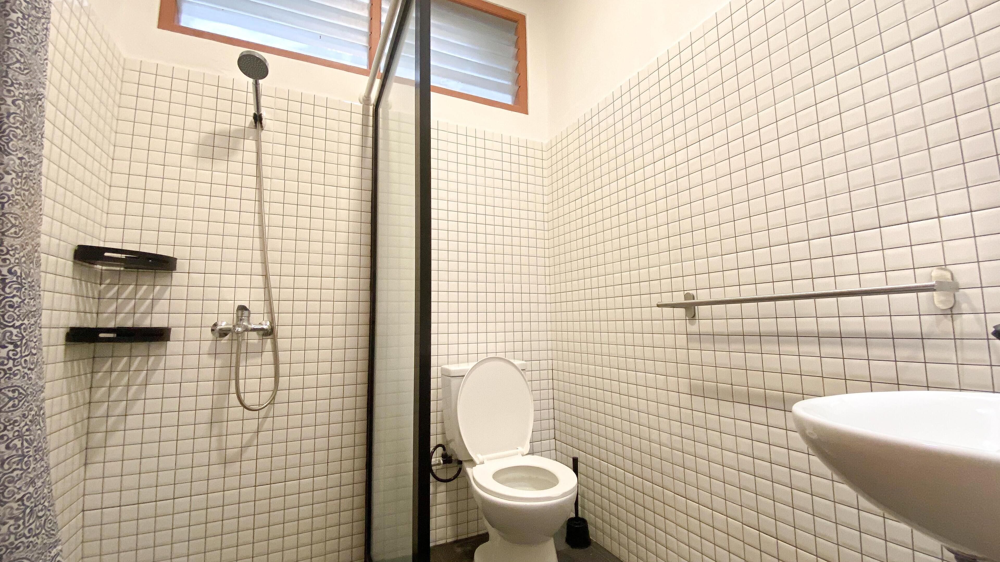 A bathroom with a shower, toilet, and sink.