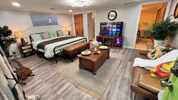 A modern living room with a bed, a coffee table, a TV, and a fireplace.