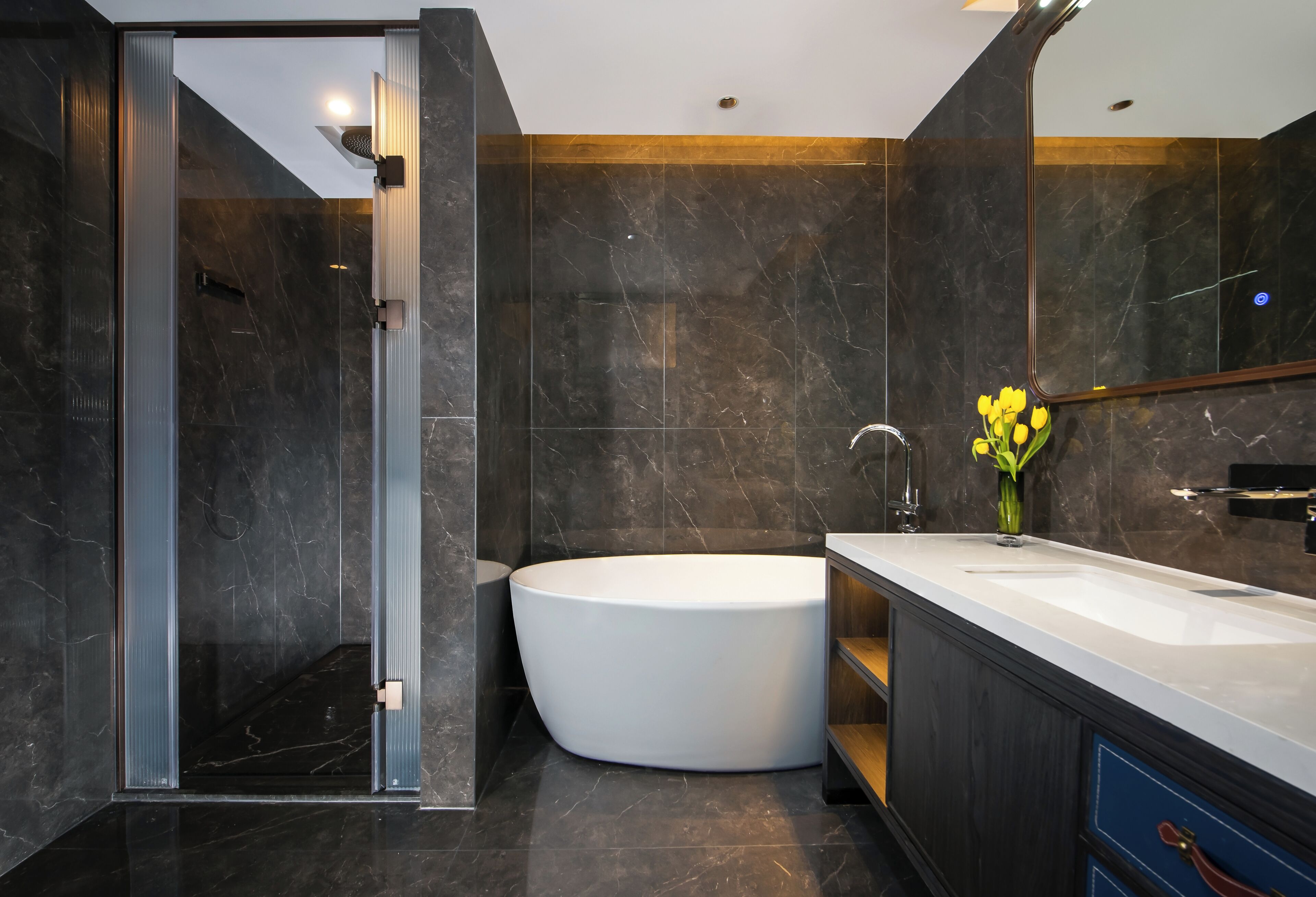A modern bathroom with a freestanding bathtub, a glass shower enclosure, and a vanity with a mirror.