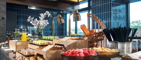 Montaje de bufé con diversos alimentos y un diseño interior moderno.