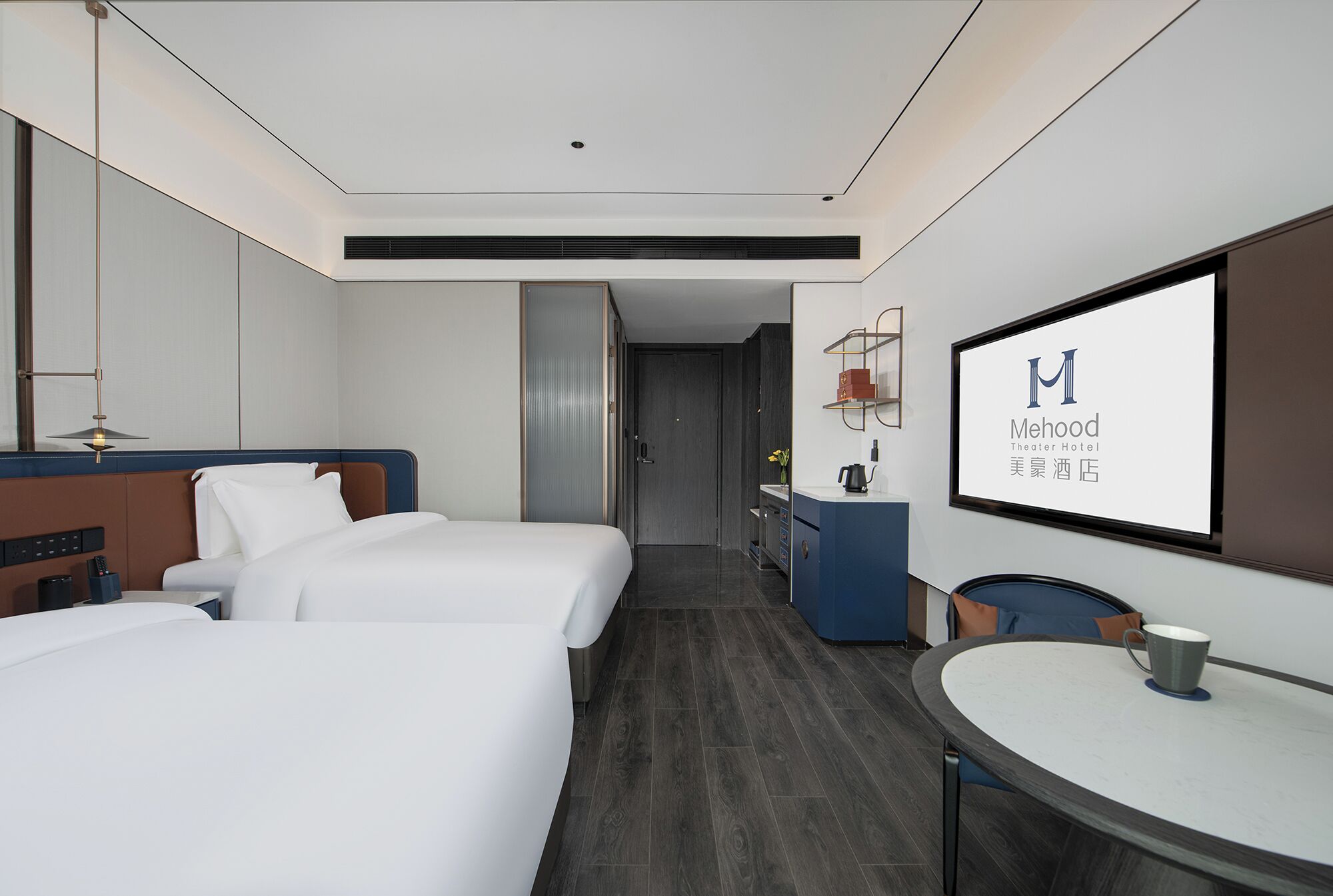 A hotel room with two beds, a desk, a chair, a TV screen, and a minibar.