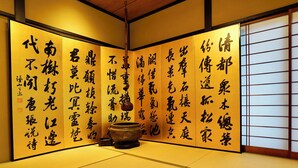 Une pièce de style japonais traditionnel, avec un sol recouvert de tatamis et des calligraphies sur les murs.