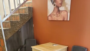 A corner with a wooden table and two chairs, a staircase, and a wall-mounted picture. - Envigado: Tradición y Modernidad (Envigado)