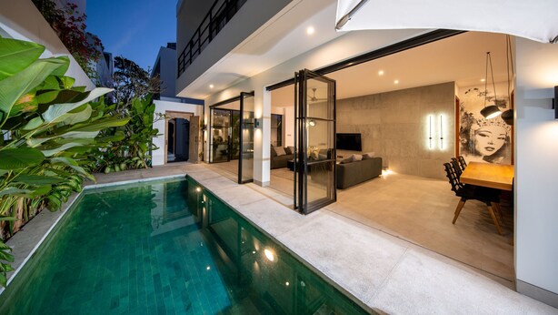 Una casa moderna con piscina, porte scorrevoli in vetro e zona pranzo.
