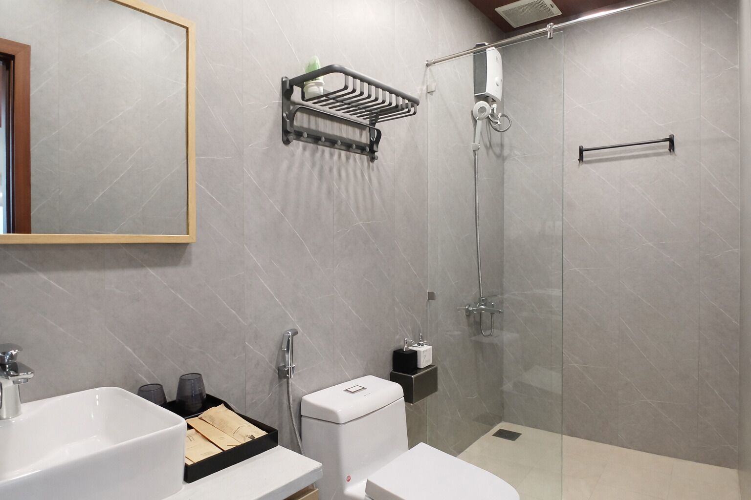 Un baño moderno con ducha, inodoro, lavabo y un perchero para toallas.