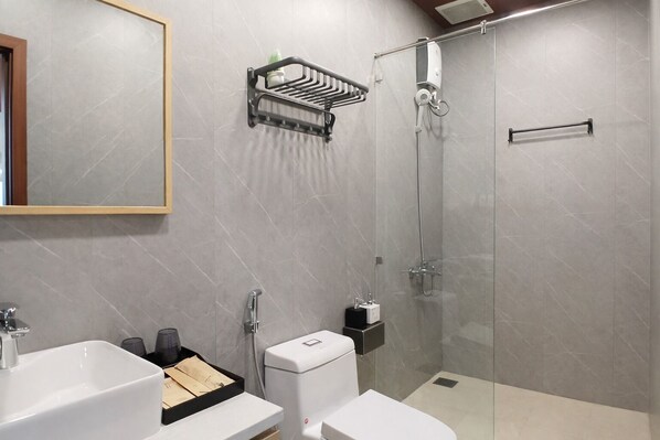 Une salle de bain moderne équipée d’une douche, de toilettes, d’un lavabo et d’un porte-serviettes.