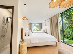 Een moderne slaapkamer met een groot bed, een douche en uitzicht op groen.