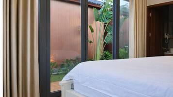 Quarto com uma grande janela, uma cama e vista para um jardim.