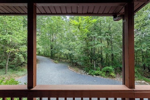 A wooden gazebo with a gravel path leading through a forest.