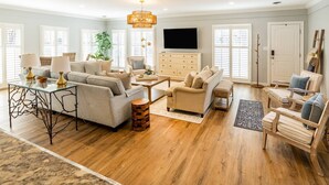 A spacious living room with a sofa set, a coffee table, and a TV.