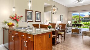 A spacious kitchen with a large island, wooden cabinets, and pendant lighting. - Honua Kai Konea Collection by KBM - 3 Units on same floor (524/537/539) (Kaanapali)