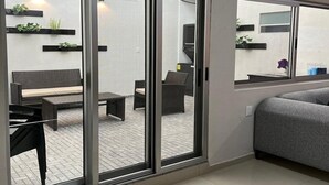 Un salon moderne doté d’une porte-fenêtre coulissante donnant sur un patio extérieur.