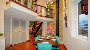 A dining area with a wooden table set for four, teal upholstered chairs, and a staircase leading to an upper level. - CASA ESMERALDA, Refined duplex 120m2 (Panama)
