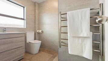A modern bathroom with a toilet, sink, and towel rack.